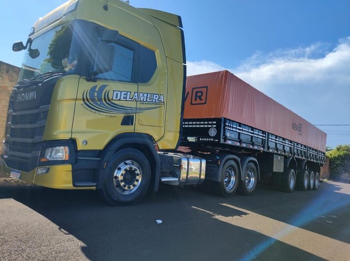Scania amarela da Delamura com graneleiro Randon de lona laranja